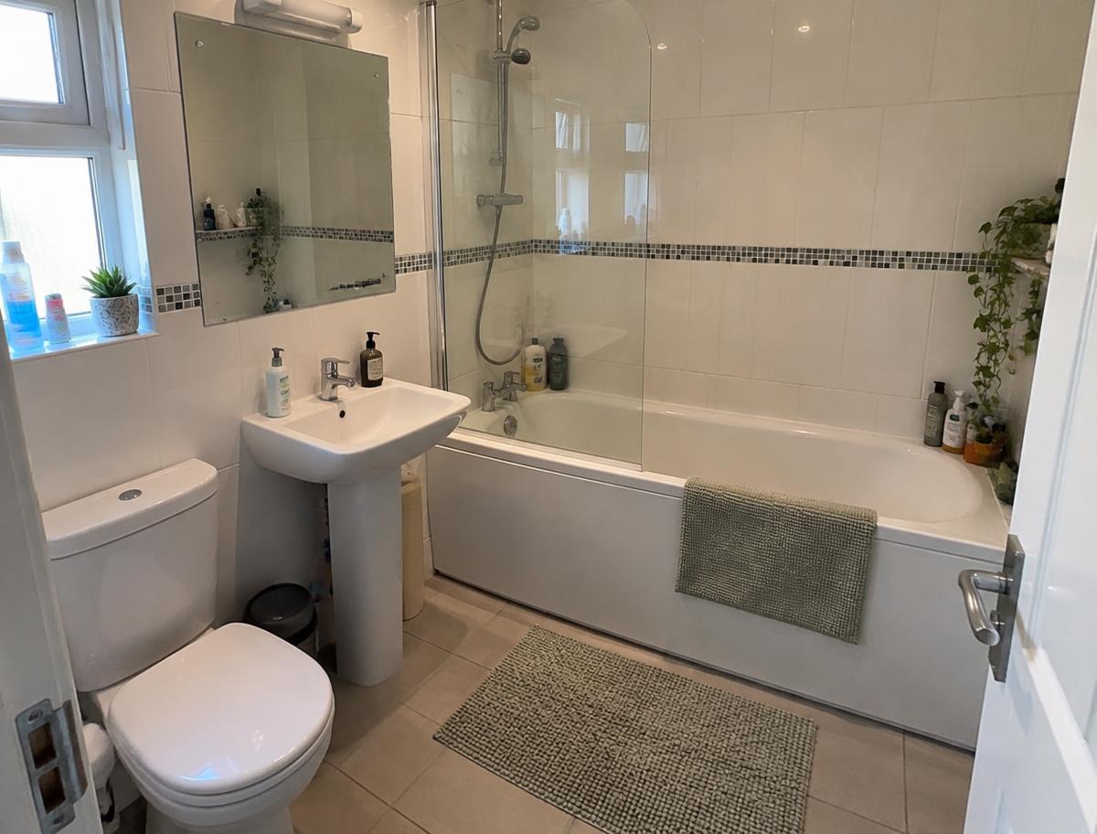 Spotless white bathroom with a gleaming glass shower screen and polished taps