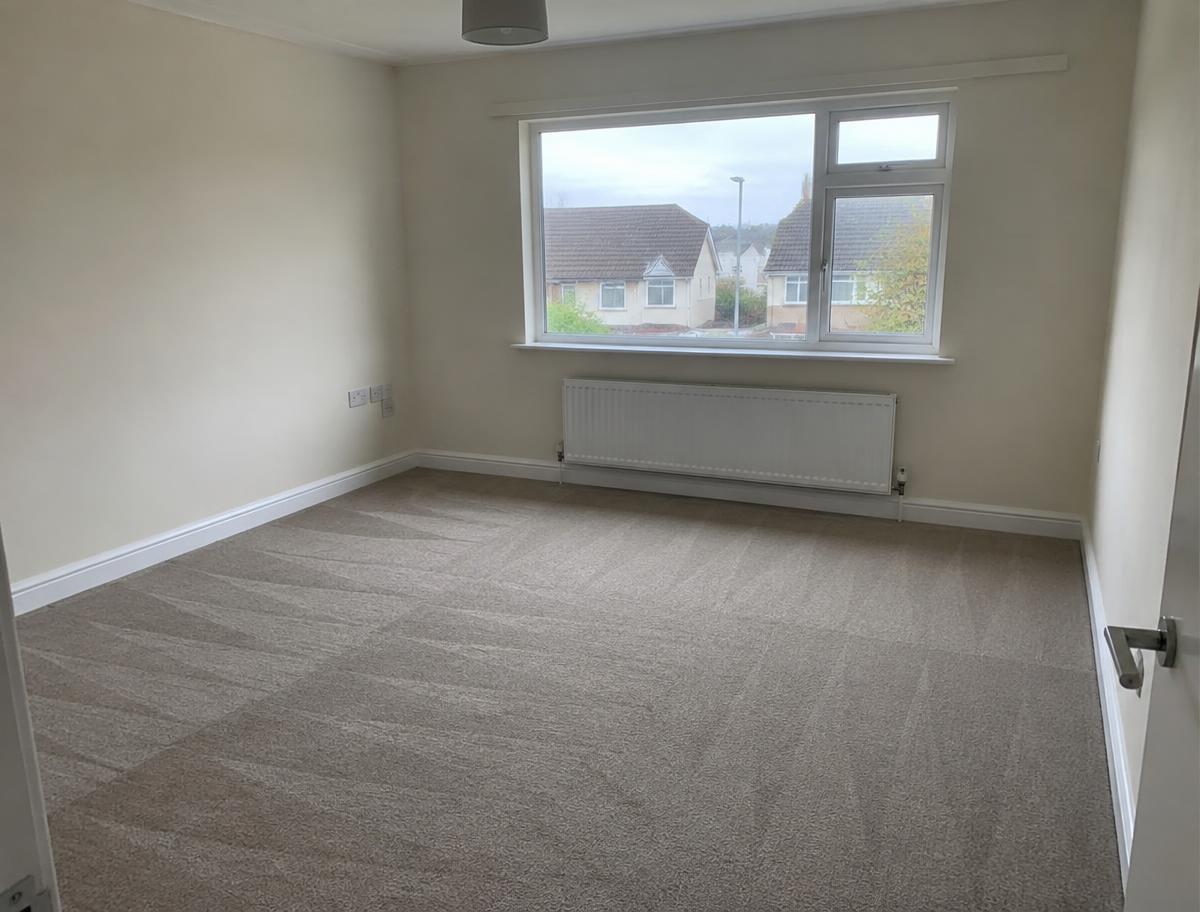 Empty, spotless rental kitchen with glossy white cupboards ready for handover